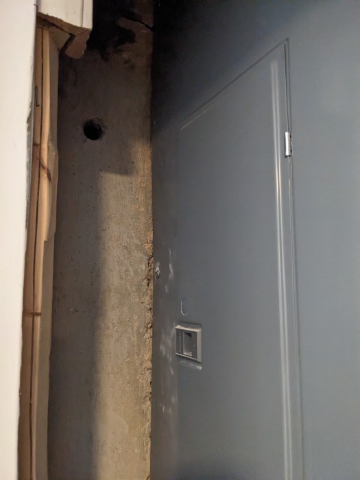 Hole cut through cement foundation into a below grade utility closet