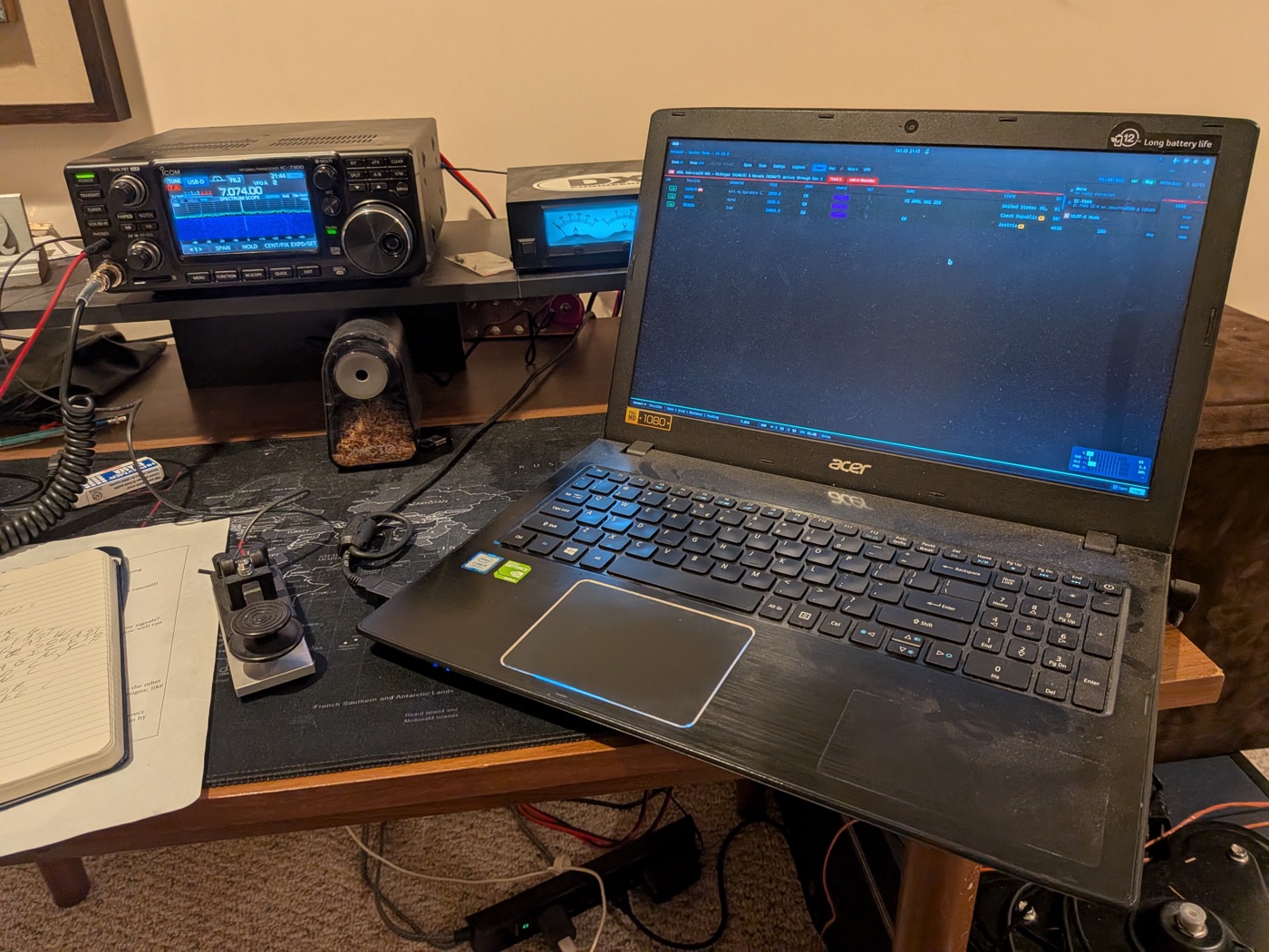 My IC-7300 on 7.074 MHz USB-D next to an old Acer laptop running POTACAT, with a paddle key and notebook on the desk